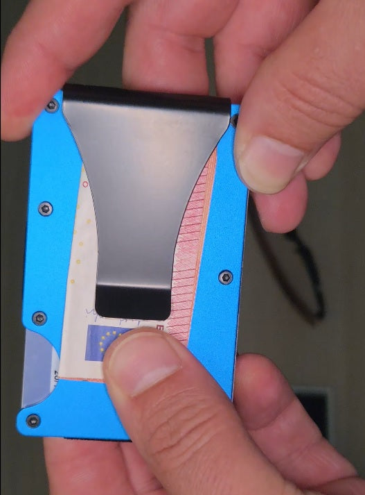 Clip para billetes sujetando euros junto a cartera de aluminio Guardian