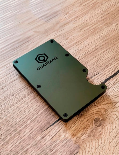 Cartera minimalista de aluminio Guardian en color verde, tumbada, con varias tarjetas asomando por el lateral y protección RFID